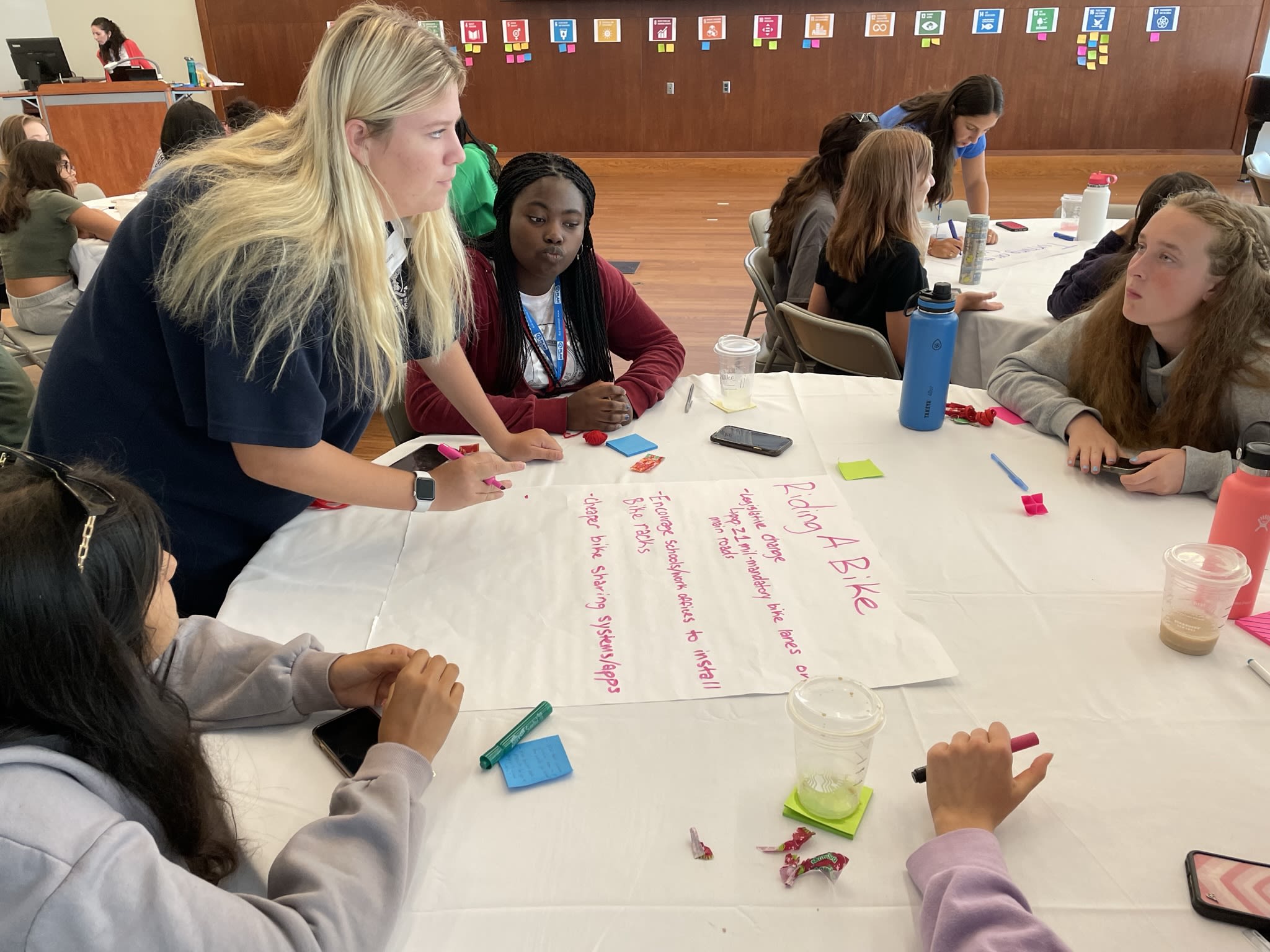 Students sitting around a table listening to group facilitator