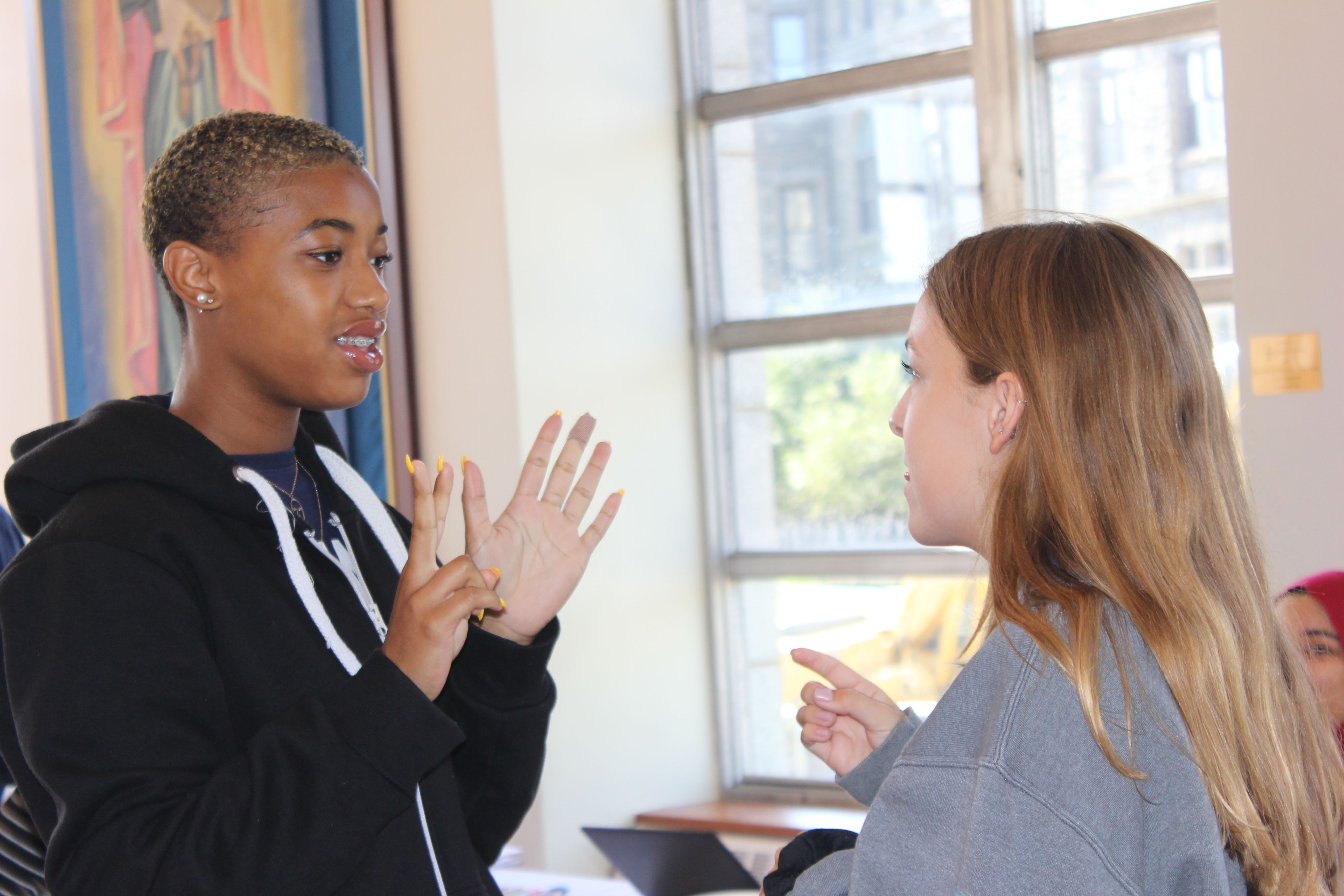 Two members of the Youth Leadership Academy speaking with each other